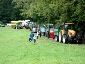 Zuschauer auf Traktoranhängern und Kutschen